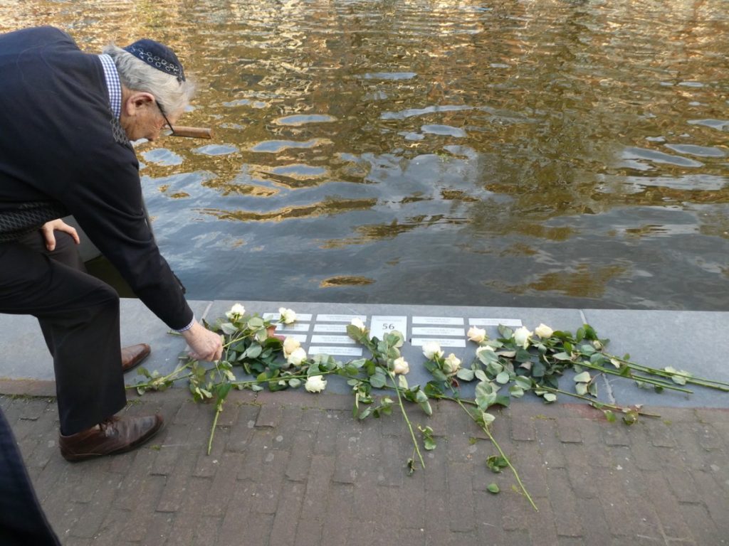 Ernest Gompers, die zojuist heeft gesproken, legt een roos voor het huis van zijn grootouders